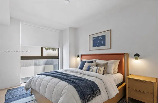 a bedroom with a bed and a night stand