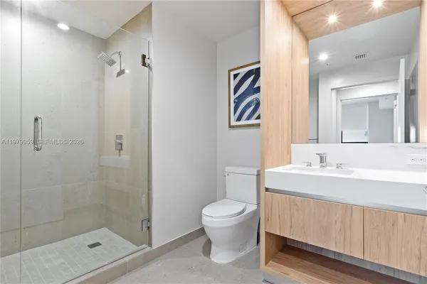 a bathroom with a sink a toilet and shower