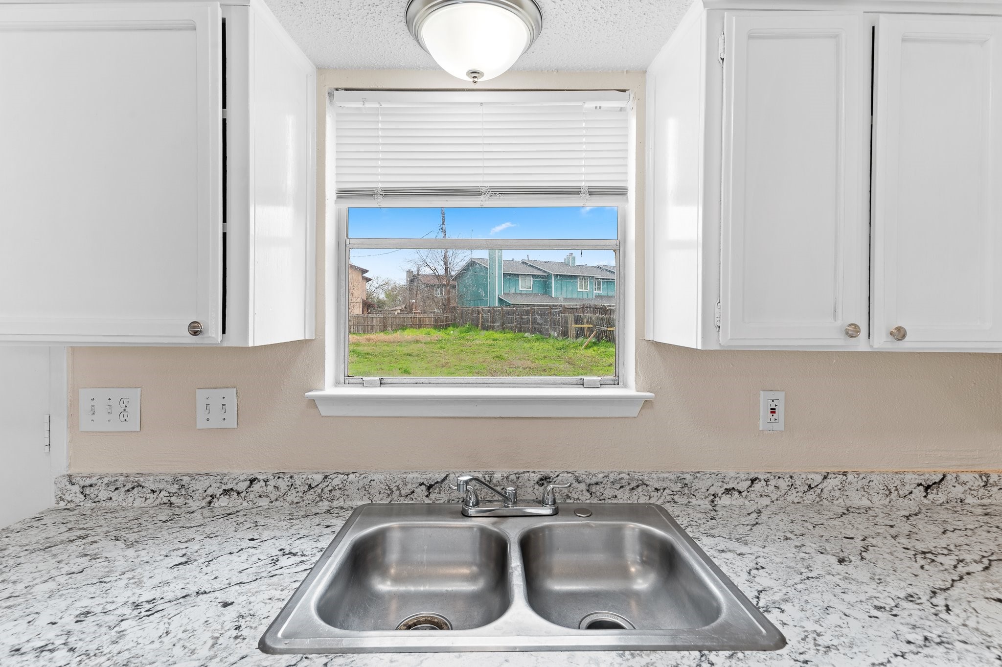 8412 Garcreek Circle, Unit D Austin, TX 78724 - Photo 13 of 23 a kitchen with a sink a window and a cabinets