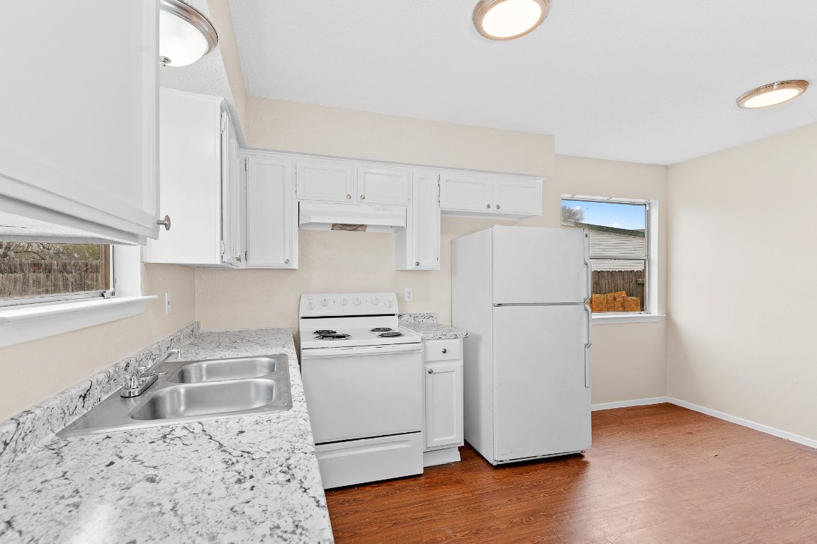 8412 Garcreek Circle, Unit D Austin, TX 78724 - Photo 10 of 23 a kitchen with a refrigerator a stove a microwave and cabinets