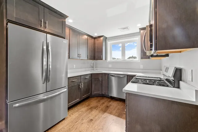 a kitchen with stainless steel appliances a refrigerator sink and cabinets