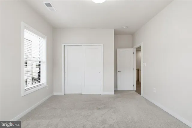 an empty room with windows and closet