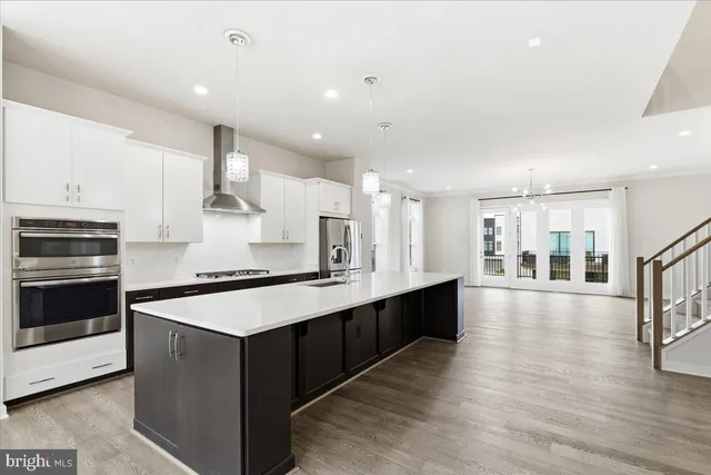 a large kitchen with stainless steel appliances a large counter top and a stove