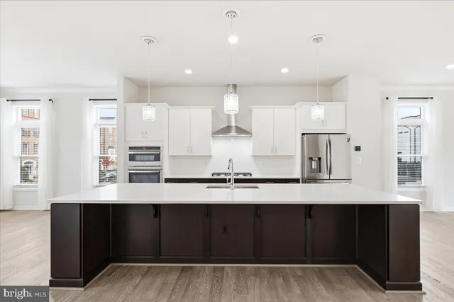a kitchen with stainless steel appliances a refrigerator and wooden cabinets