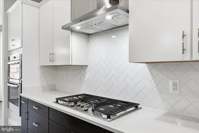 a stove top oven sitting inside of a kitchen