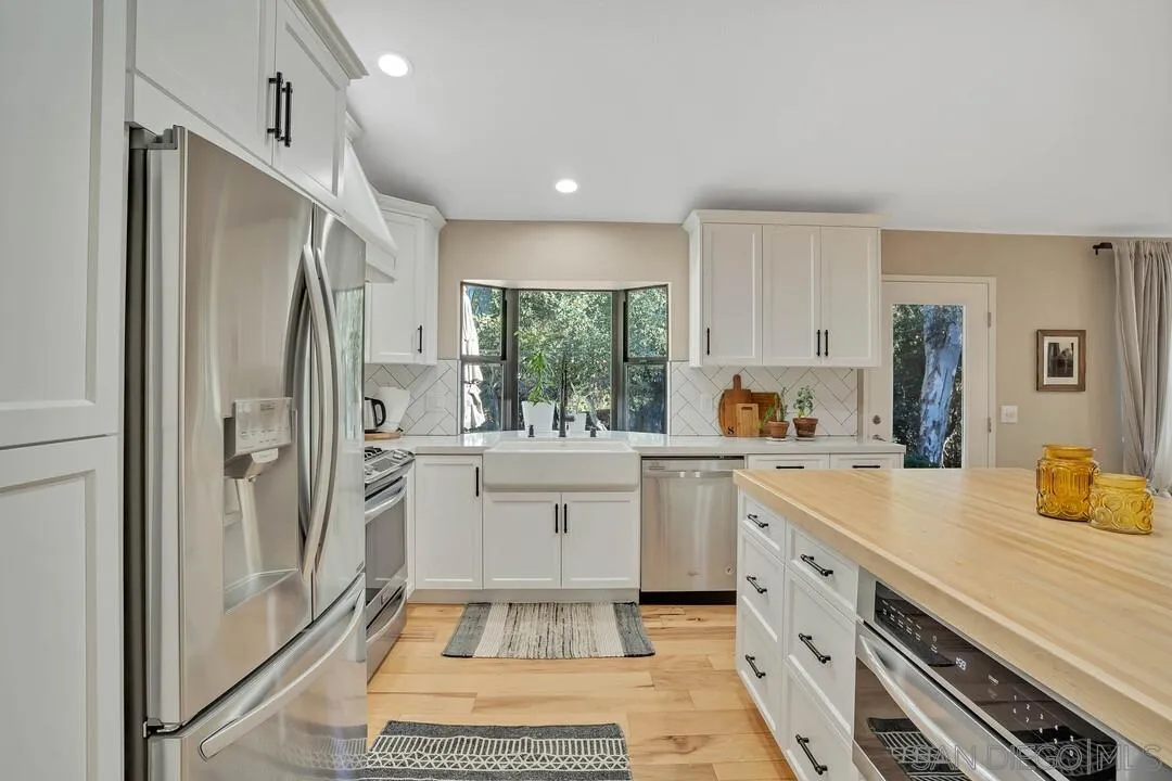 15867 Prairie Vista Road Poway, CA 92064 - Photo 14 of 70 a kitchen with a refrigerator a sink and cabinets