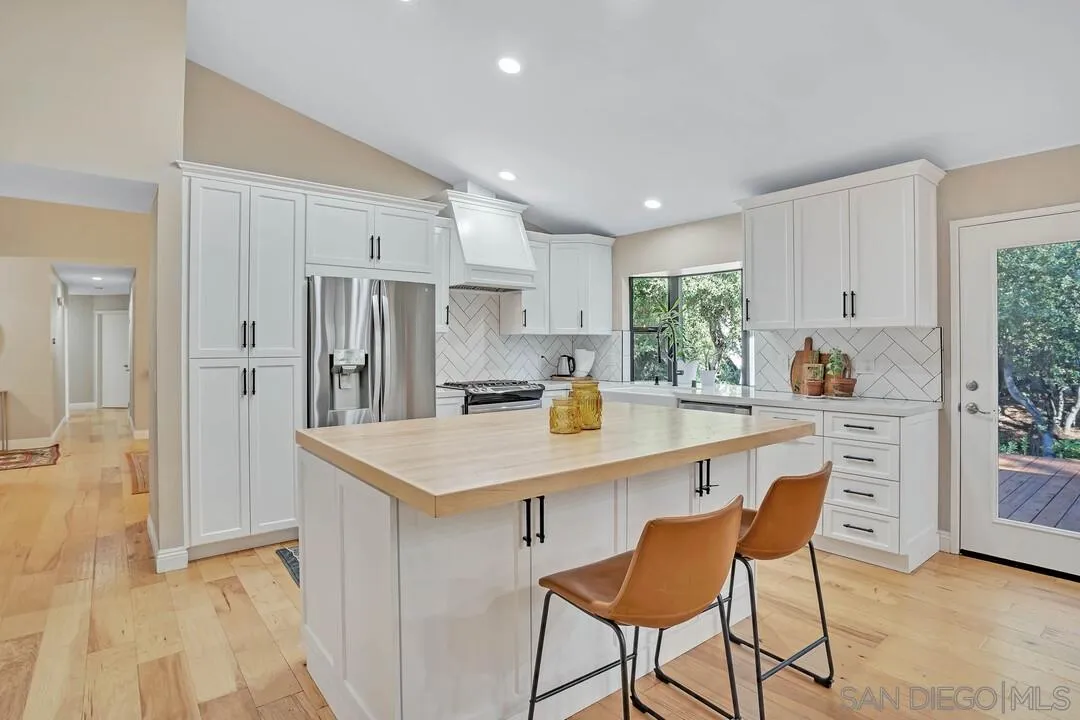15867 Prairie Vista Road Poway, CA 92064 - Photo 16 of 70 a kitchen with stainless steel appliances granite countertop a refrigerator a sink a stove a dining table and chairs