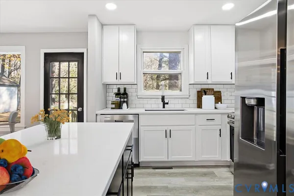 a kitchen with kitchen island a sink stainless steel appliances and cabinets