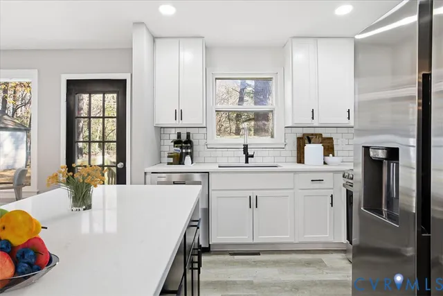 a kitchen with kitchen island a sink stainless steel appliances and cabinets