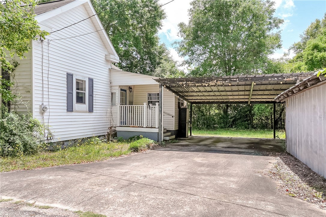 59 Church Street Notasulga, AL 36866 - Photo 18 of 38 This charming home offers a welcoming porch and a convenient carport for sheltered parking.