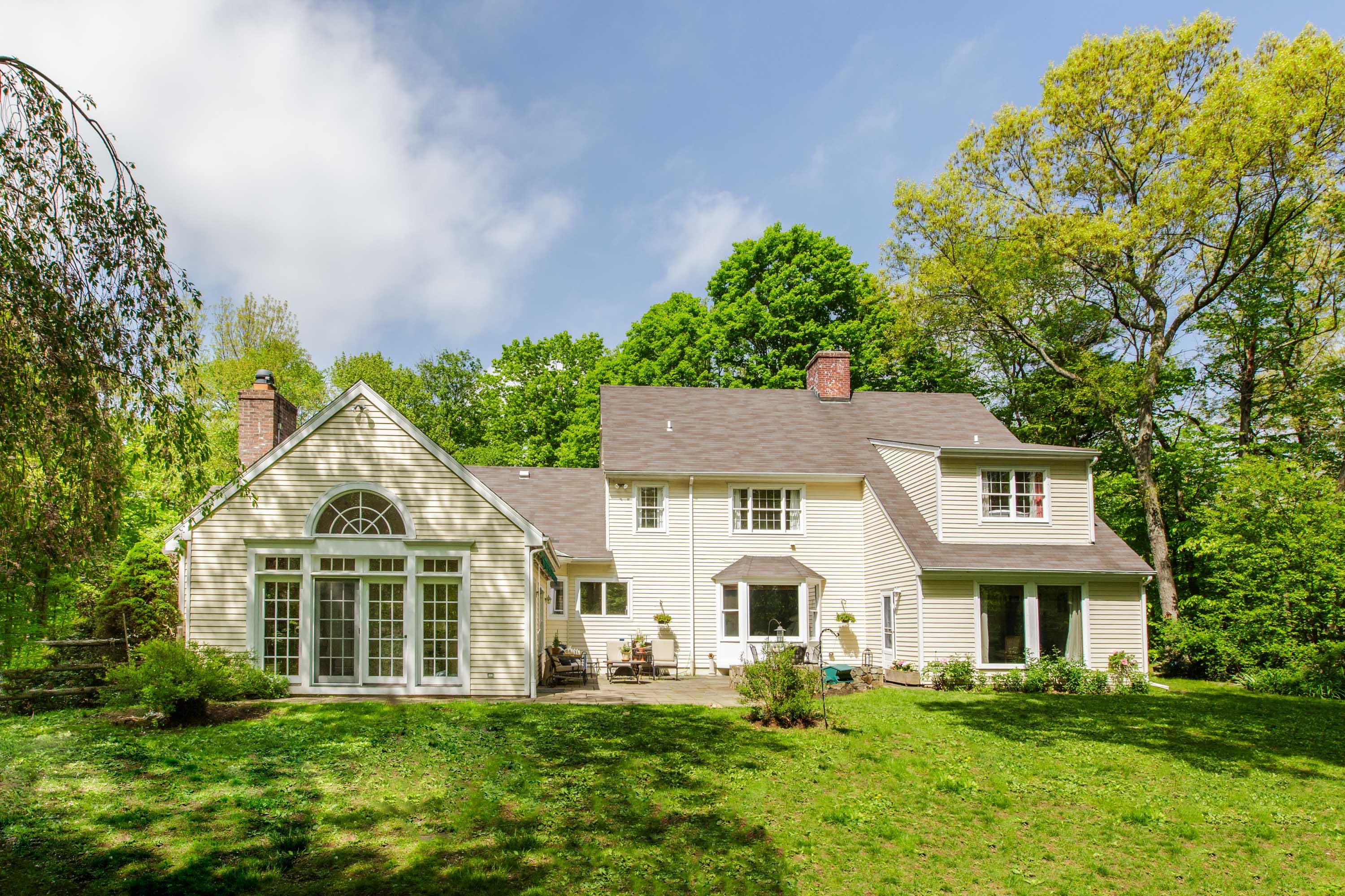135 Mill Road New Canaan, CT 06840 - Photo 1 of 16 a front view of a house with a yard