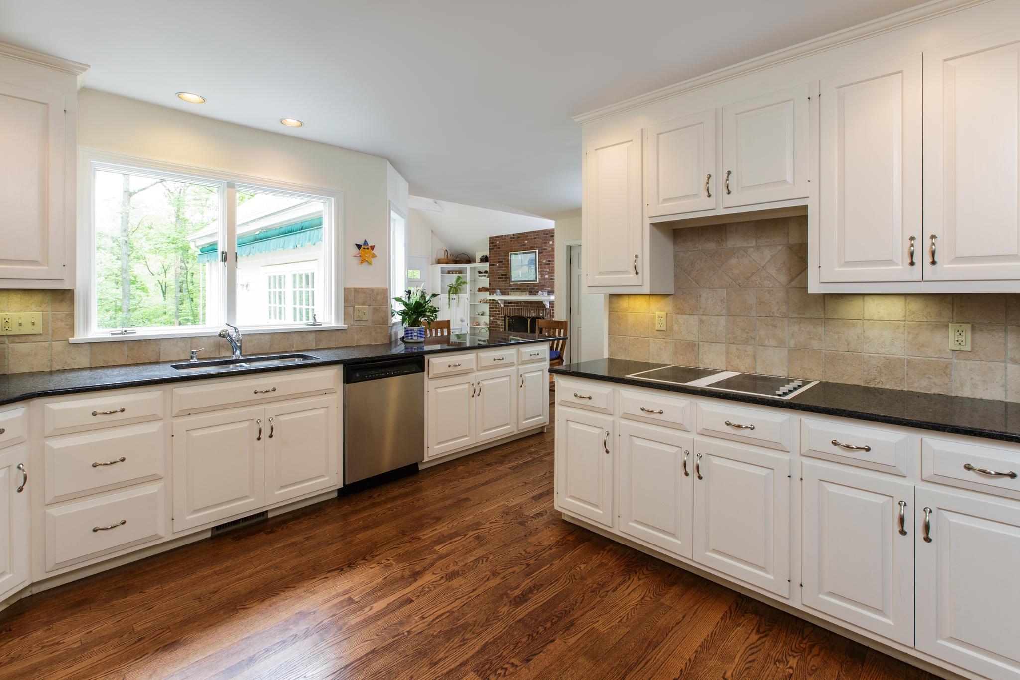 135 Mill Road New Canaan, CT 06840 - Photo 4 of 16 a kitchen with granite countertop white cabinets white appliances a sink and a window