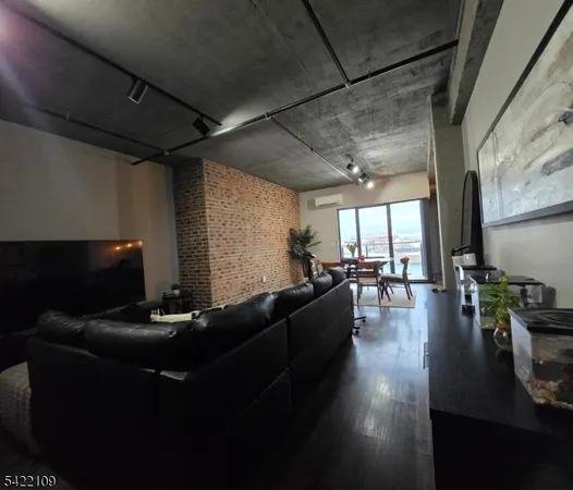 a living room with couches a flat screen tv and kitchen view