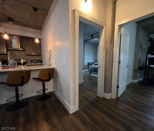a view of a hallway with wooden floor and furniture