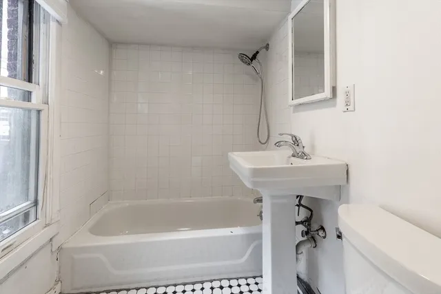 a white bath tub sitting next to a white sink