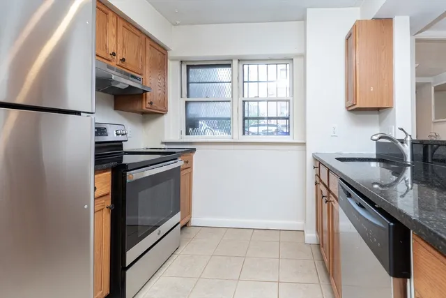 a kitchen with stainless steel appliances granite countertop a sink stove and cabinets
