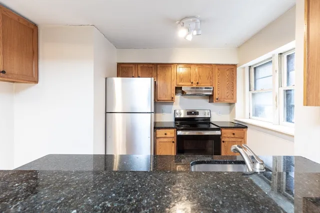 a kitchen with stainless steel appliances granite countertop a refrigerator stove top oven and sink