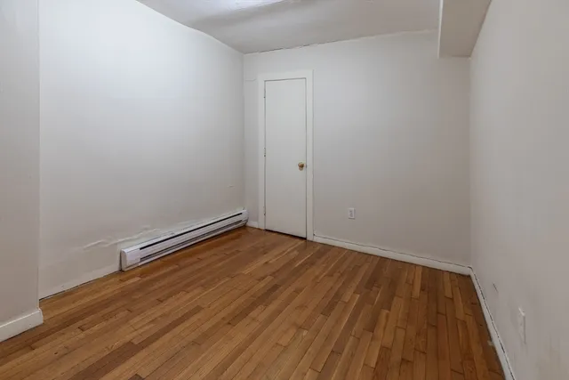 a view of a room with wooden floor and white walls