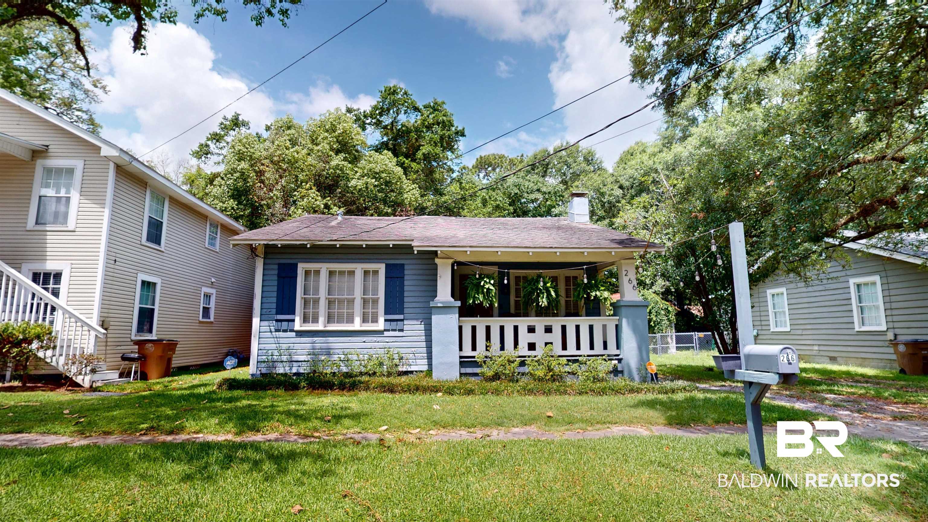 266 Westwood Street Mobile, AL 36606 - Photo 2 of 34 View of front of home featuring a front yard, covered porch, a chimney, and roof with shingles