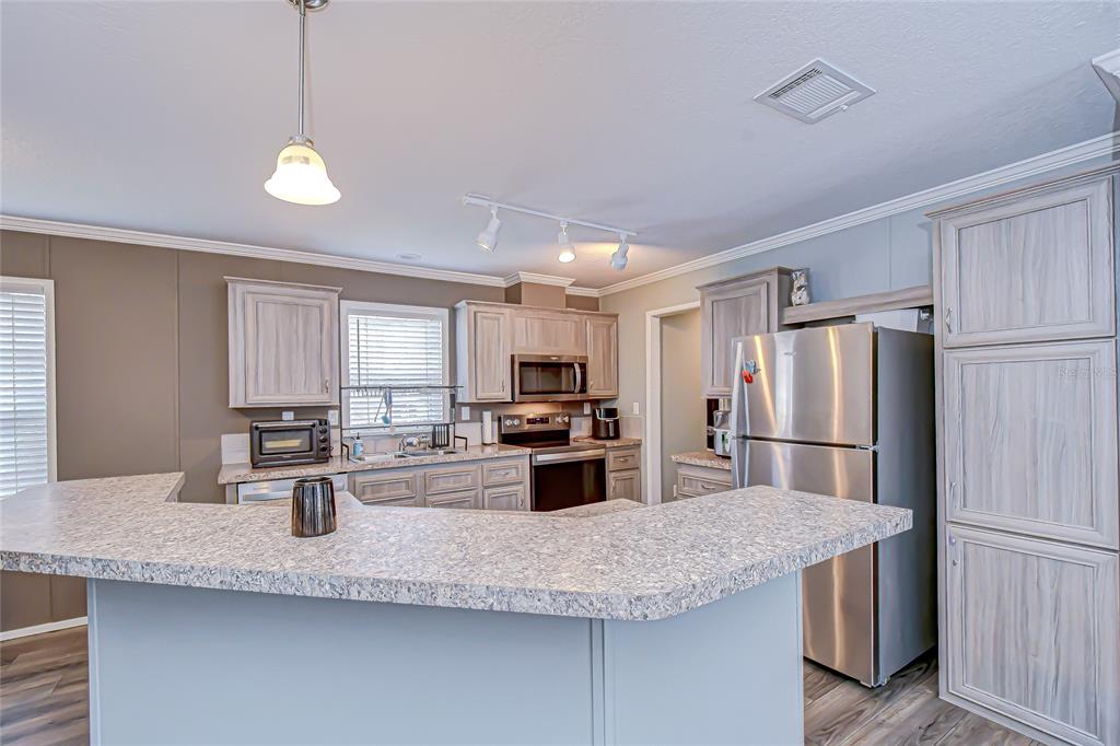 37749 Geiger Road Zephyrhills, FL 33542 - Photo 11 of 36 a kitchen with refrigerator and stove