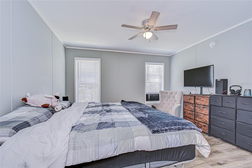 37749 Geiger Road Zephyrhills, FL 33542 - Photo 21 of 36 a bedroom with a large bed and flat tv