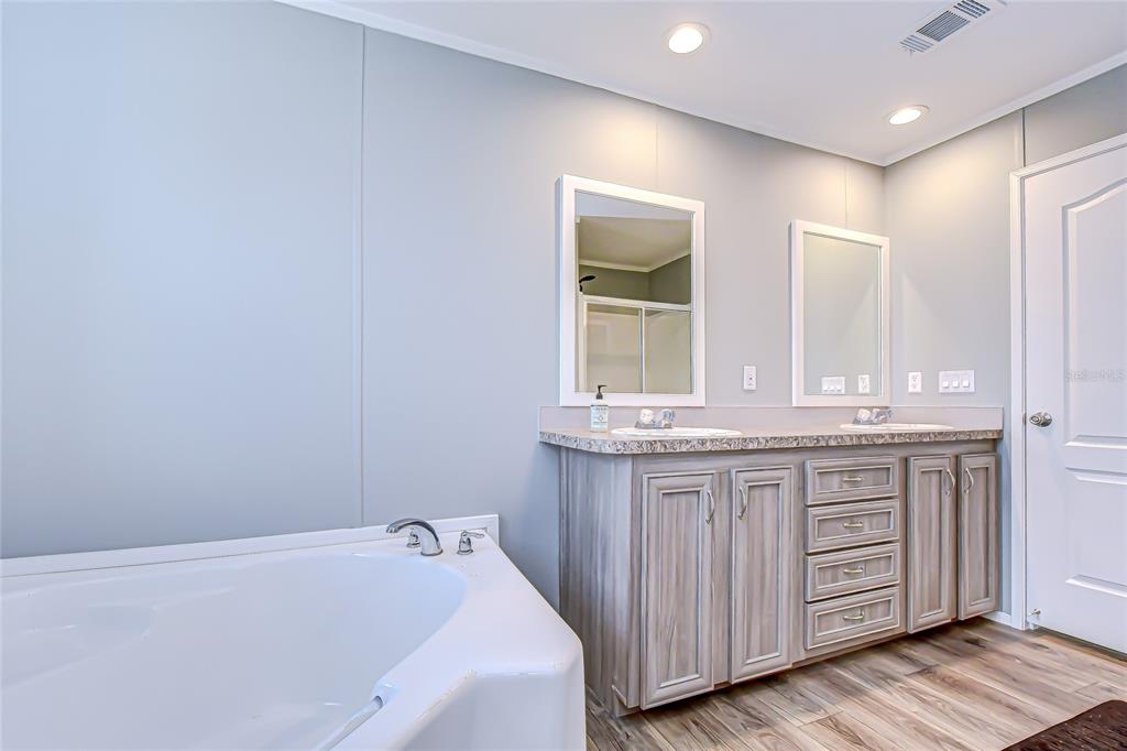 37749 Geiger Road Zephyrhills, FL 33542 - Photo 25 of 36 a bathroom with a granite countertop sink and a bathtub
