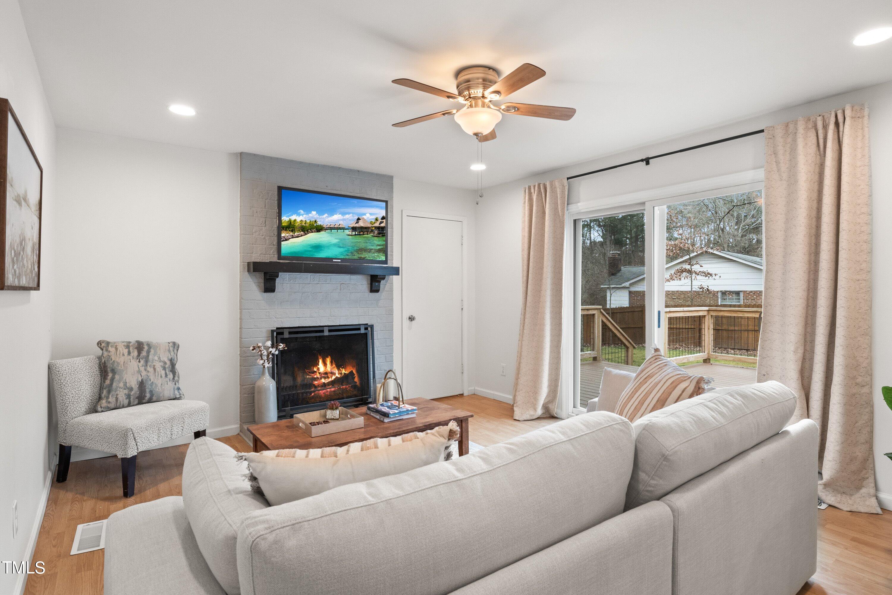 1 Kellom Court Durham, NC 27713 - Photo 15 of 33 a living room with furniture a fireplace and a flat screen tv