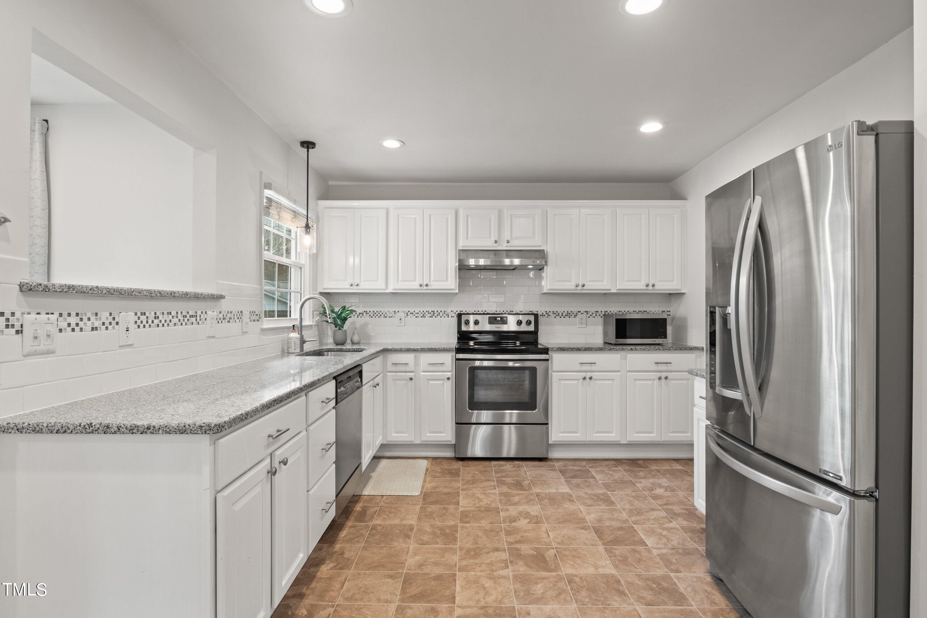 1 Kellom Court Durham, NC 27713 - Photo 17 of 33 a kitchen with granite countertop a refrigerator sink and cabinets