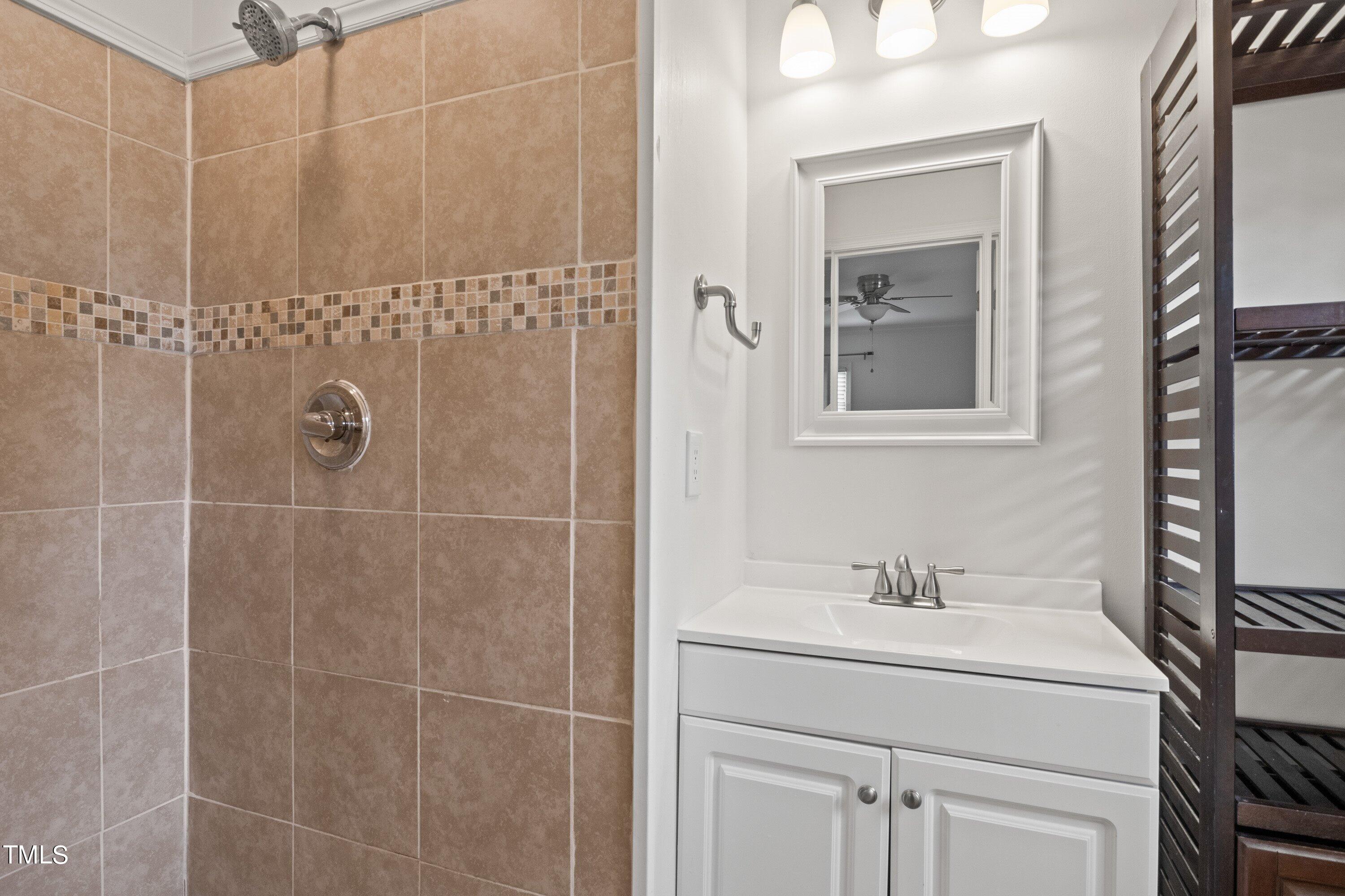 1 Kellom Court Durham, NC 27713 - Photo 21 of 33 a bathroom with a shower sink vanity and mirror