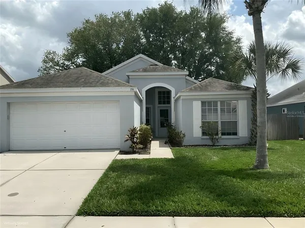 a front view of a house with a garden and yard