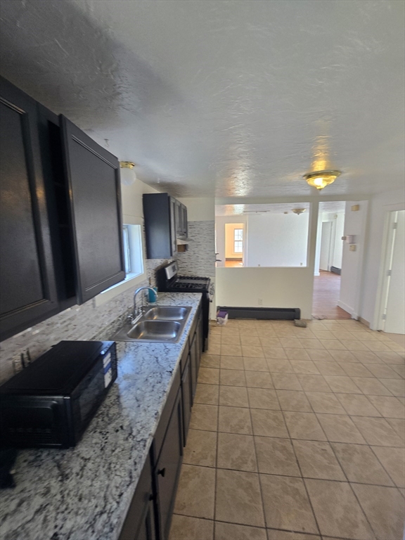 176 Green Street, Unit 2 Brockton, MA 02301 - Photo 12 of 15 a large kitchen with kitchen island granite countertop a sink and a stove