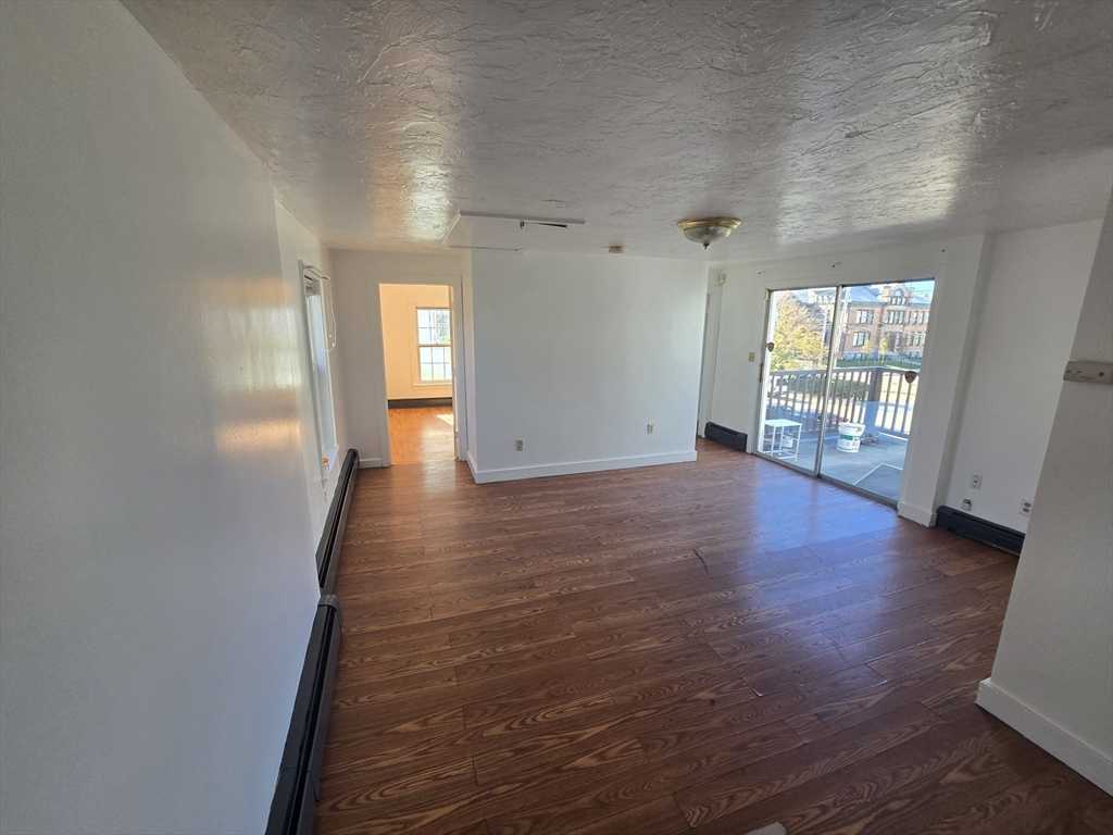 176 Green Street, Unit 2 Brockton, MA 02301 - Photo 9 of 15 wooden floor in an empty room with a window