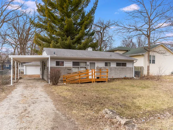 a view of a house with a yard and large tree