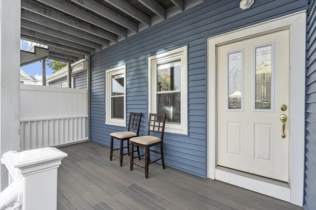 a view of a house with wooden deck and furniture