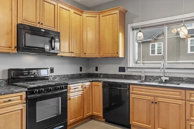 a kitchen with stainless steel appliances granite countertop a sink stove and microwave