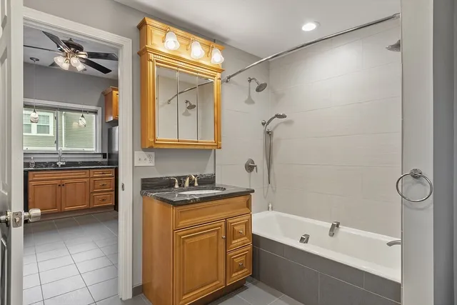 a bathroom with a tub sink and mirror