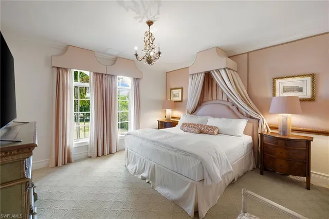 a bedroom with a large bed and a chandelier