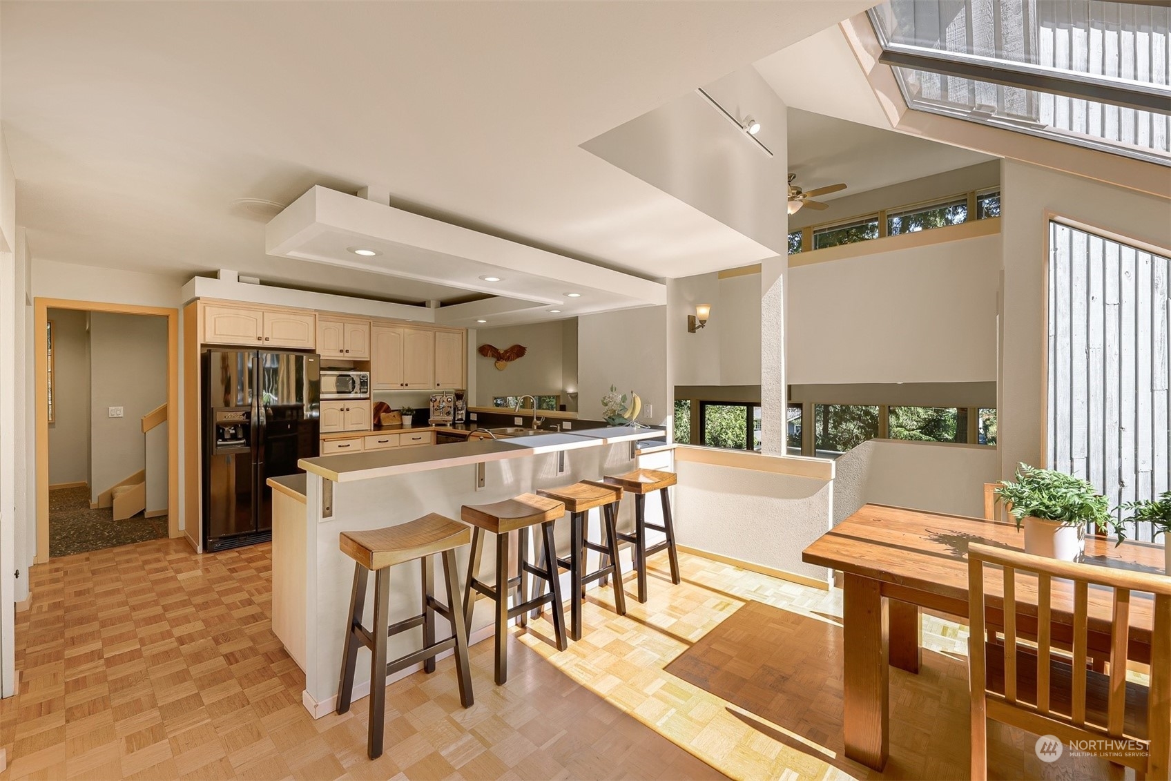 4431 Ferncroft Road Mercer Island, WA 98040 - Photo 12 of 40 a kitchen with stainless steel appliances kitchen island granite countertop a table and chairs in it