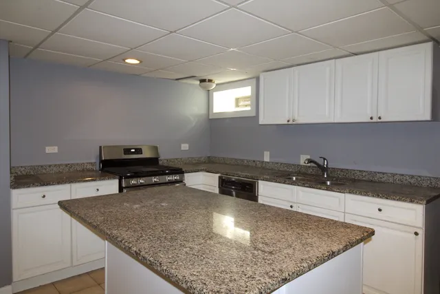 a kitchen with a sink a stove and cabinets