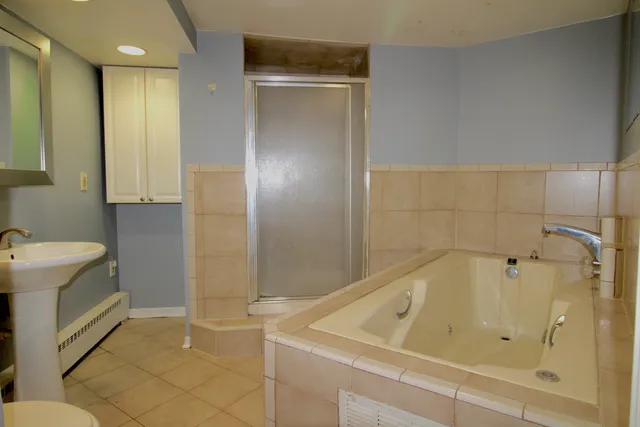 a bathroom with a tub a sink and a shower