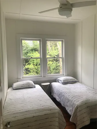 a bedroom with two beds and a large window