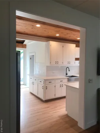 a large kitchen with a lot of counter space and wooden floor