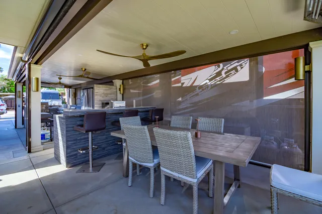 a view of a patio with table and chairs under an umbrella