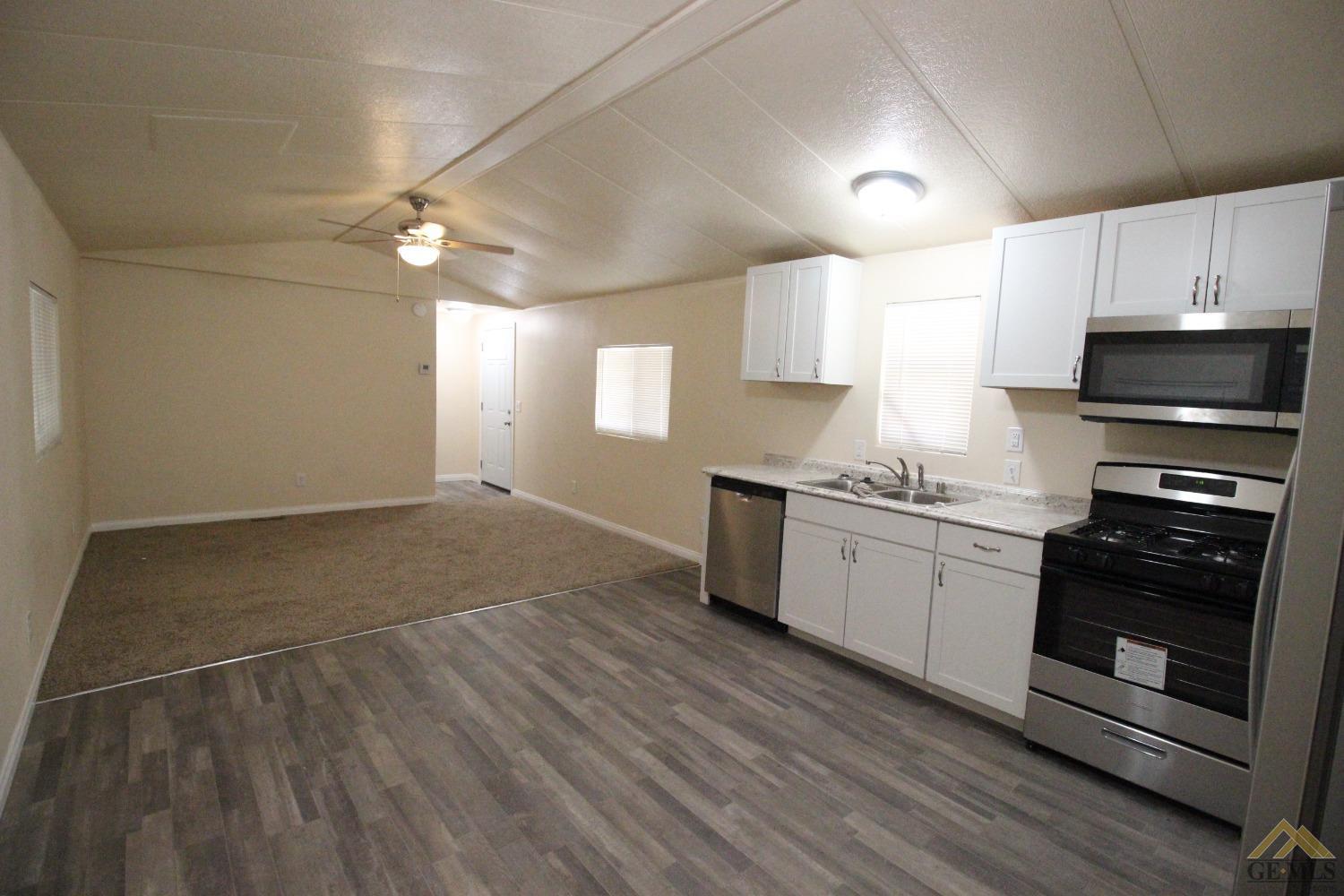 Undisclosed Address Bakersfield, CA 93308 - Photo 3 of 25 a kitchen with granite countertop a stove cabinets and wooden floor