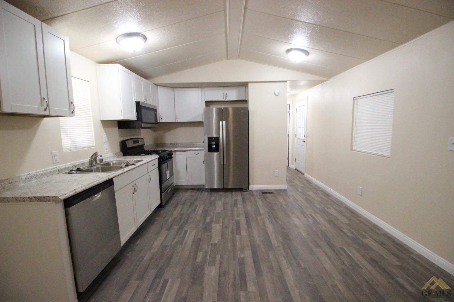 Undisclosed Address Bakersfield, CA 93308 - Photo 6 of 25 a large kitchen with stainless steel appliances granite countertop a lot of counter space and wooden floor