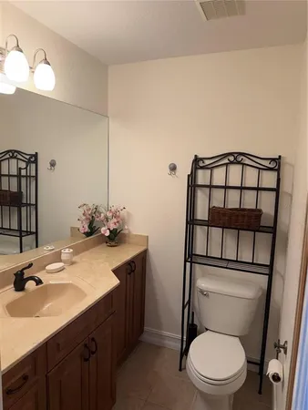 a bathroom with a toilet a sink and mirror