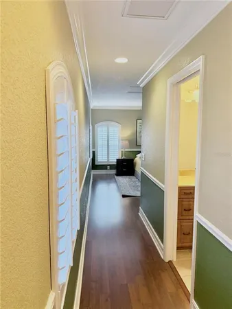 a view of a hallway view with wooden floor and a living room