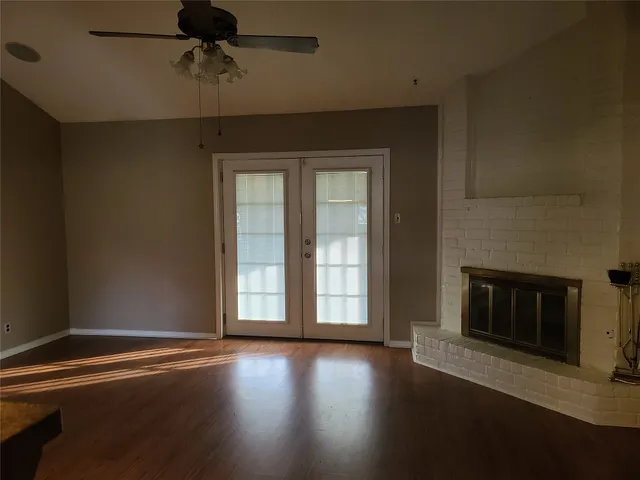 a view of a livingroom with wooden floor and a fireplace