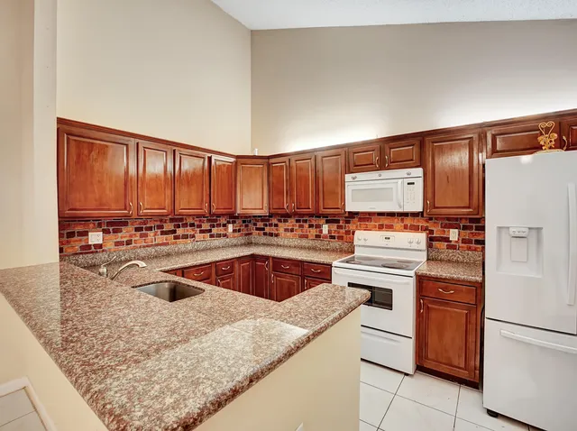 a kitchen with stainless steel appliances granite countertop a refrigerator sink and cabinets