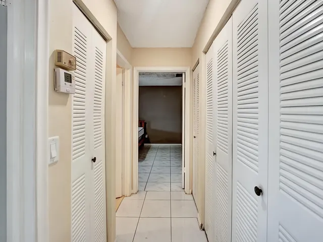 a view of a hallway with a white door and a bathroom